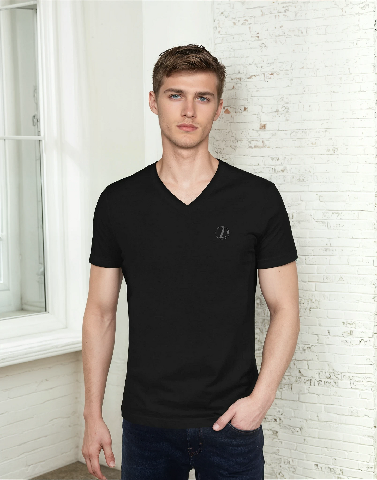 Man wearing a black V-neck t-shirt with a L'Obscurite logo against a white brick wall.