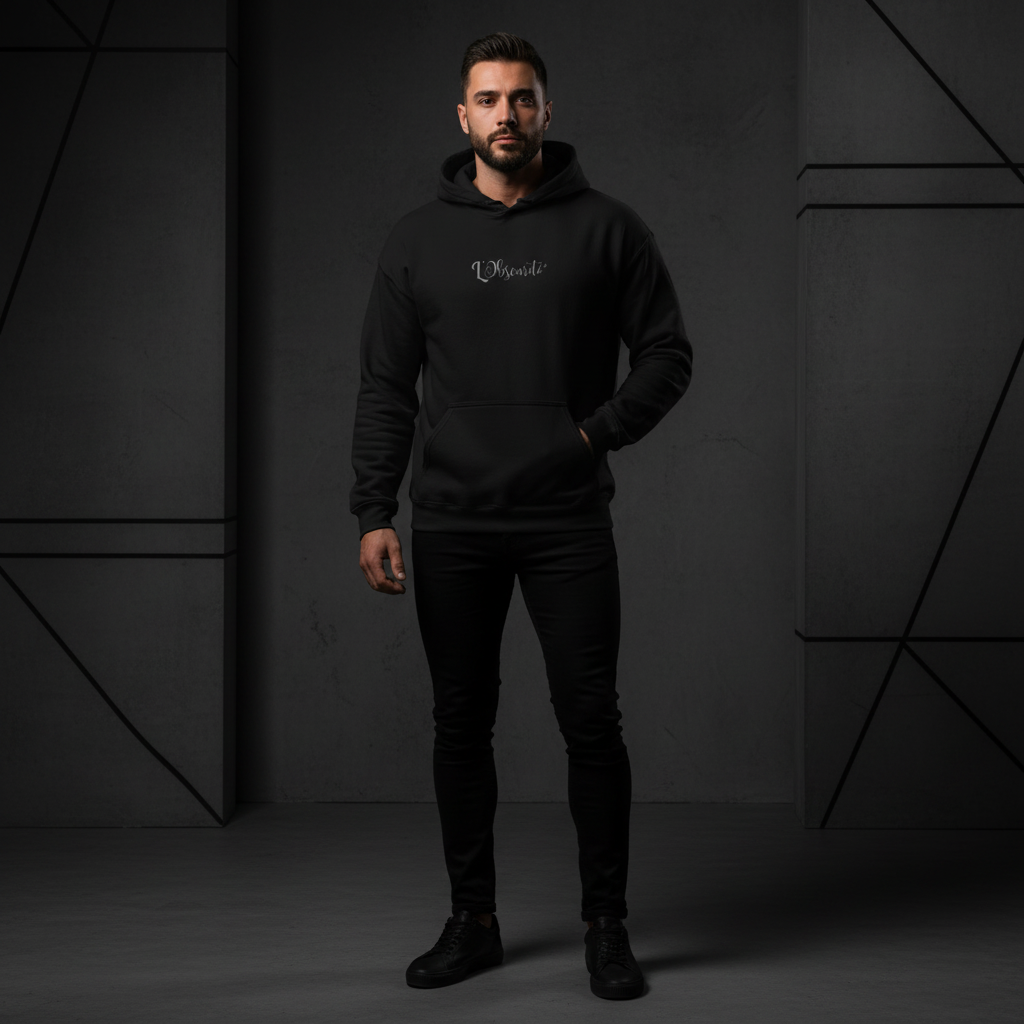 Man wearing a black hoodie with a logo against a dark geometric-patterned background