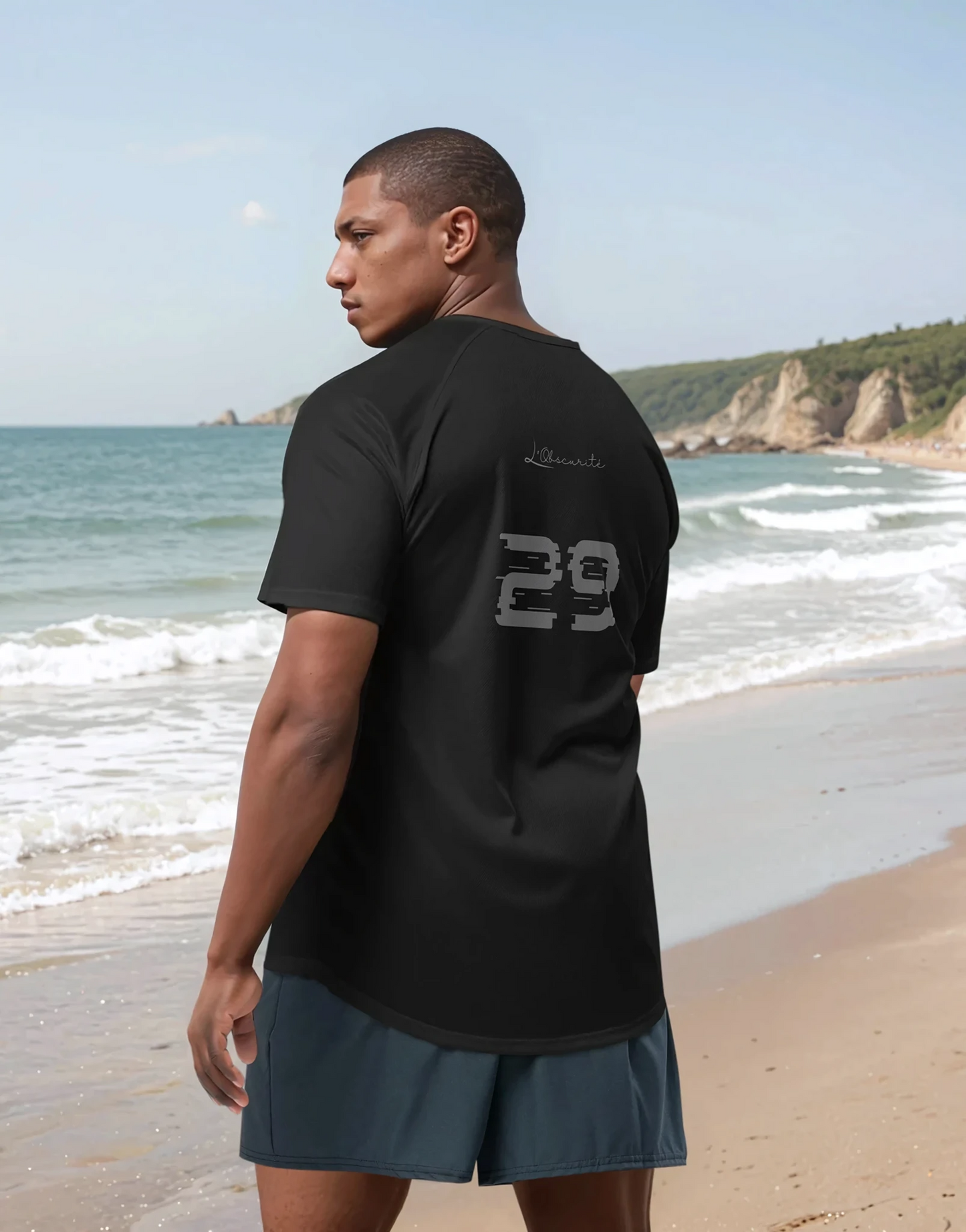 Man wearing a black t-shirt with '29' logo on the beach, Mark 29 Jersey