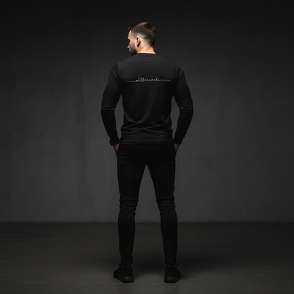 Man wearing a black long-sleeve shirt with a logo on the back against a dark background