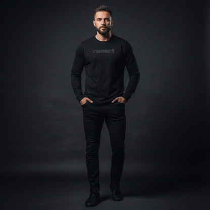 Man wearing a black long-sleeve shirt with text on a dark background, bold and direct long sleeve tee