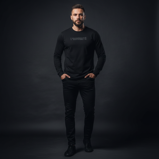 Man wearing a black long-sleeve shirt with text on a dark background, bold and direct long sleeve tee