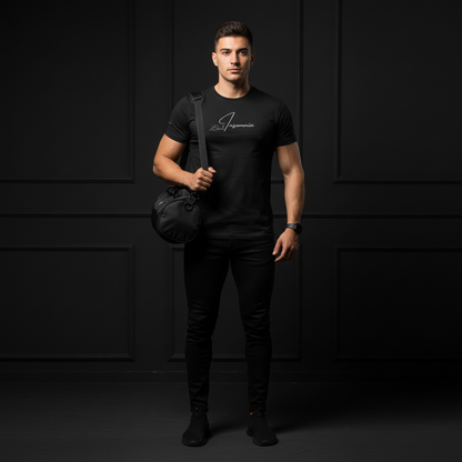 Man wearing a black t-shirt with a logo insomnia, holding a black bag against a dark background
