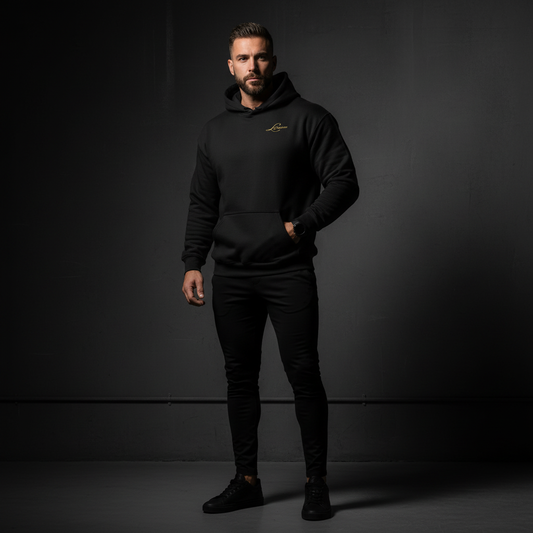 Man wearing a black hoodie with a classic logo on a dark background.