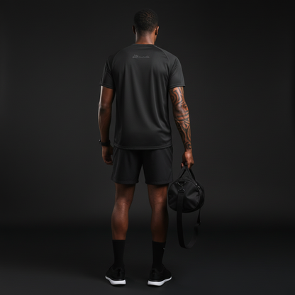 Person wearing black athletic gear holding a black duffel bag against a dark background