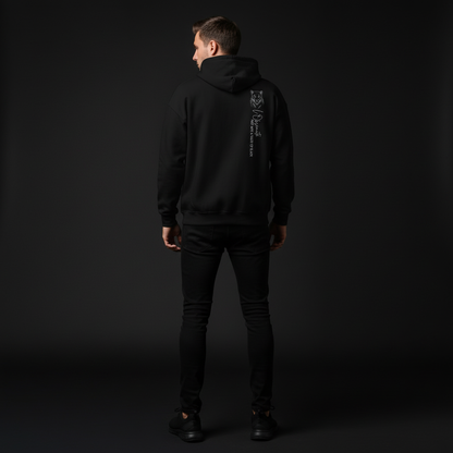 Person wearing a black hoodie with a logo on the back against a dark background, shade of black hoodie