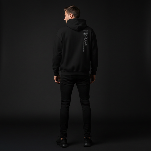 Person wearing a black hoodie with a logo on the back against a dark background, shade of black hoodie