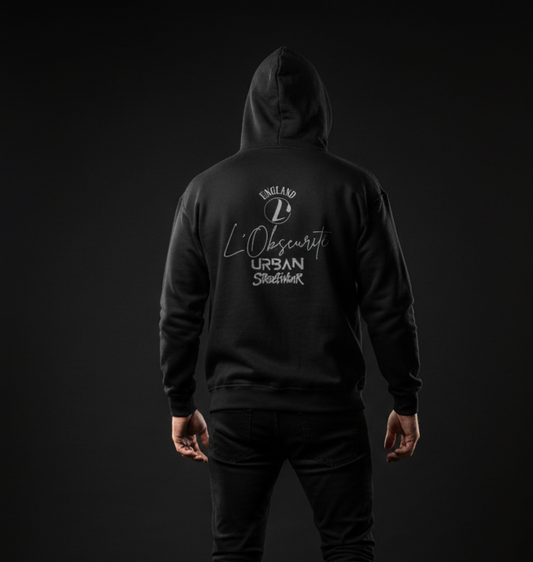 Person wearing a black hoodie with white text on the back against a dark background, urban streetwear