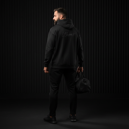 Person wearing a black hoodie with white text on the back against a dark background, urban streetwear
